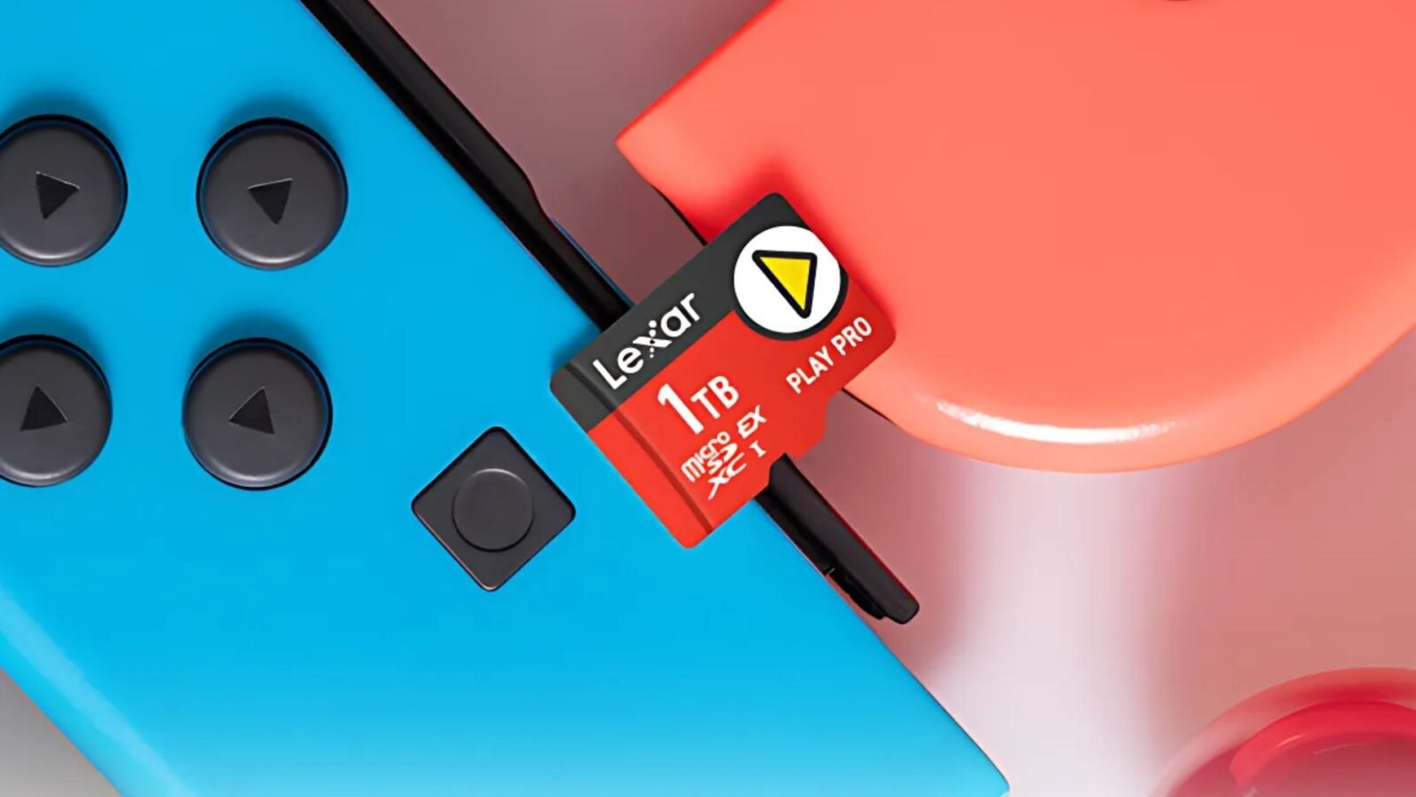 Um cartão de memória microSD vermelho Lexar de 1TB está posicionado acima de dois Joy-Cons azul e vermelho. O texto "Lexar", "1TB", "microSD EX PLAY PRO XC I" e um triângulo amarelo são visíveis no cartão.