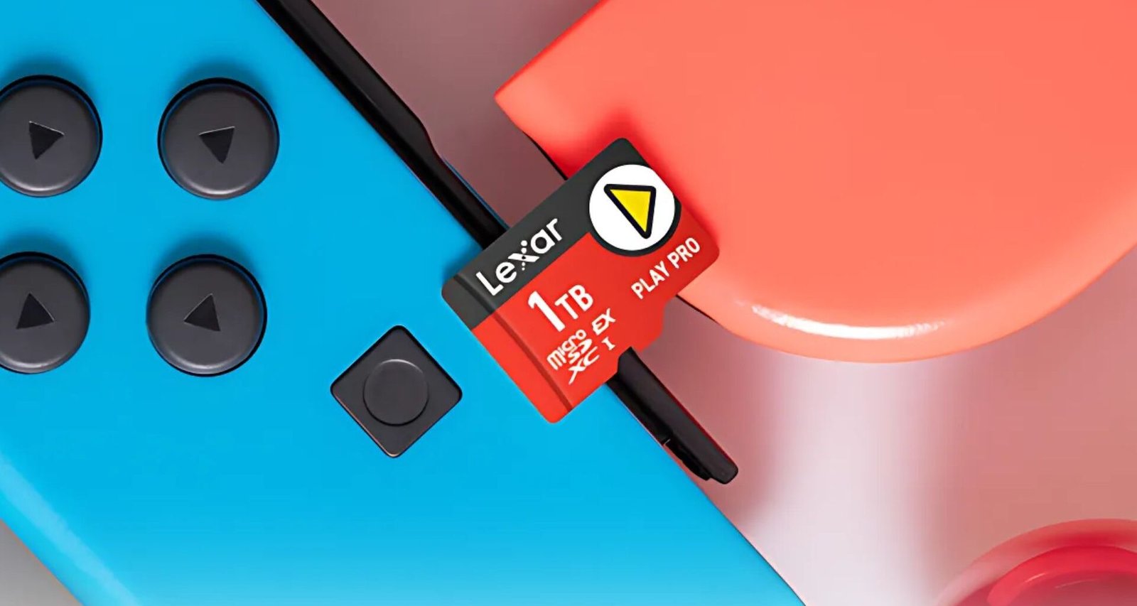 Um cartão de memória microSD vermelho Lexar de 1TB está posicionado acima de dois Joy-Cons azul e vermelho. O texto "Lexar", "1TB", "microSD EX PLAY PRO XC I" e um triângulo amarelo são visíveis no cartão.