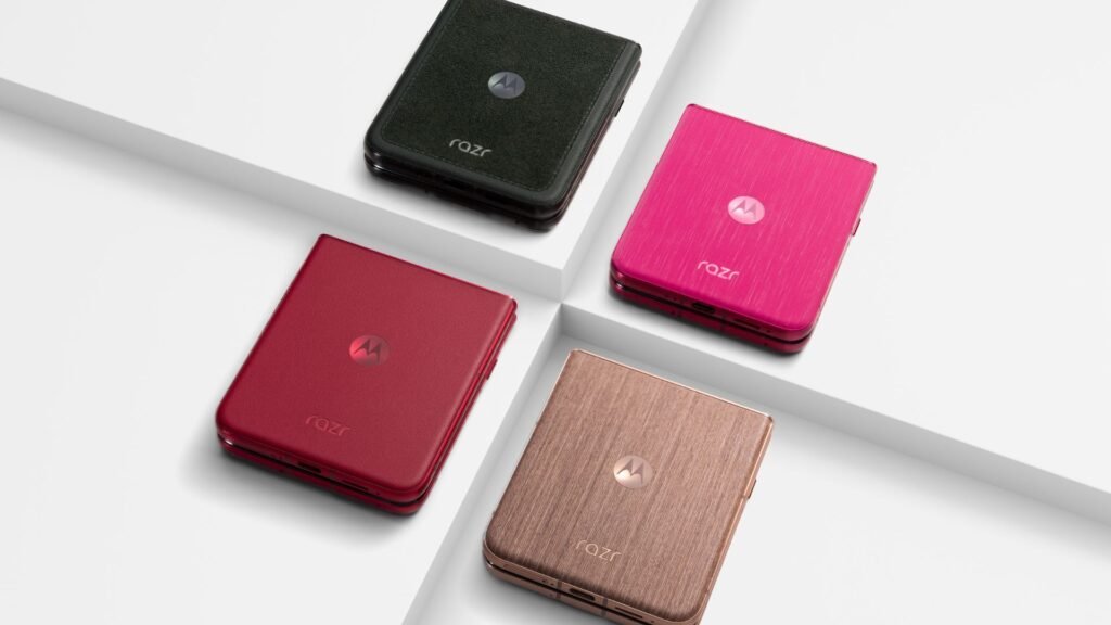 A imagem exibe quatro smartphones Motorola Razr 60 Ultra em diferentes cores – preto, rosa, vermelho e bronze/dourado – dispostos sobre uma superfície branca com sombras suaves. Cada telefone dobrado apresenta a marca "razr" e o logotipo da Motorola.