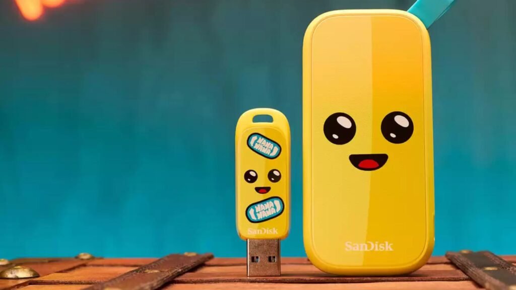 Um SSD Portátil SanDisk Fortnite Peely Edition em uma superficie de madeira e fundo verde. O SSD está ao lado de um pendrive. Ambos trazem a personalização inspirada no personagem Peely de Fortnite (que é uma banana) com olhos e boca estilo desenho animado