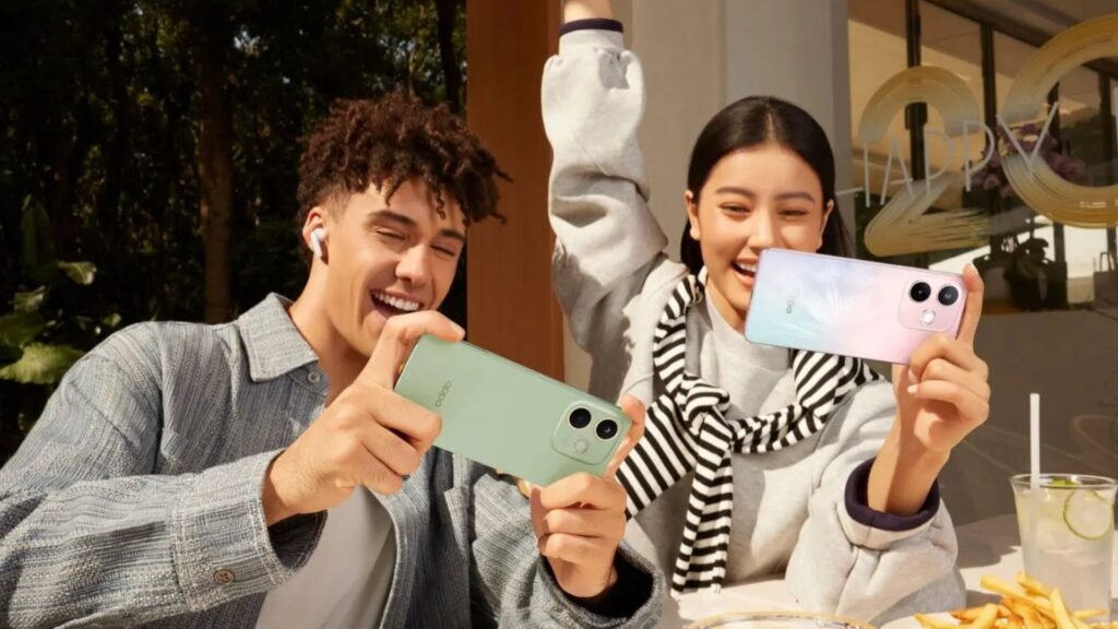Um jovem e uma jovem sorriem enquanto usam seus smartphones OPPO A5 Pro 5G em uma área externa de um café. O rapaz, à esquerda, segura um aparelho verde na horizontal, enquanto a moça, à direita, segura um aparelho lilás e rosa e ergue um braço em sinal de comemoração.