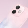 Close-up em ângulo da parte traseira do smartphone OPPO A5 Pro 5G. O aparelho tem um acabamento perolado em tons de rosa claro, com um reflexo azulado na parte inferior esquerda. O módulo de câmera, com duas lentes pretas grandes e um flash circular, está em destaque. O fundo é um rosa sólido e suave que complementa a cor do telefone.