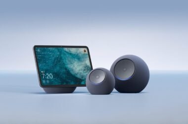 Três novos dispositivos da linha Amazon Echo 2025, todos na cor grafite e com acabamento em tecido. A imagem exibe o Echo Show com tela, o Echo Dot Max (esférico e menor) e o Echo Studio (esférico e maior).