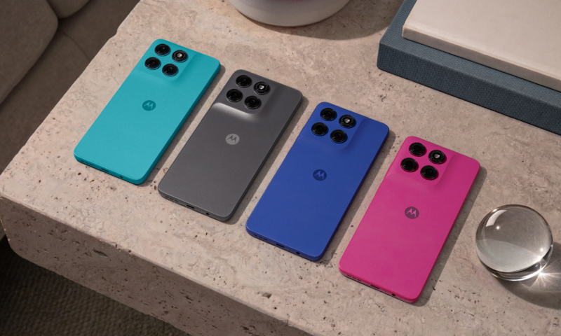 Quatro smartphones Motorola Moto G47 vistos pela traseira, dispostos lado a lado sobre uma superfície clara de pedra. Da esquerda para a direita, os aparelhos estão nas cores oficiais: Capri (Azul Turquesa), Impenetrable (Grafite), Nautical Blue (Azul Náutico) e Fuchsia Red (Rosa). Todos exibem um módulo com quatro câmeras e o logotipo da Motorola ao centro.